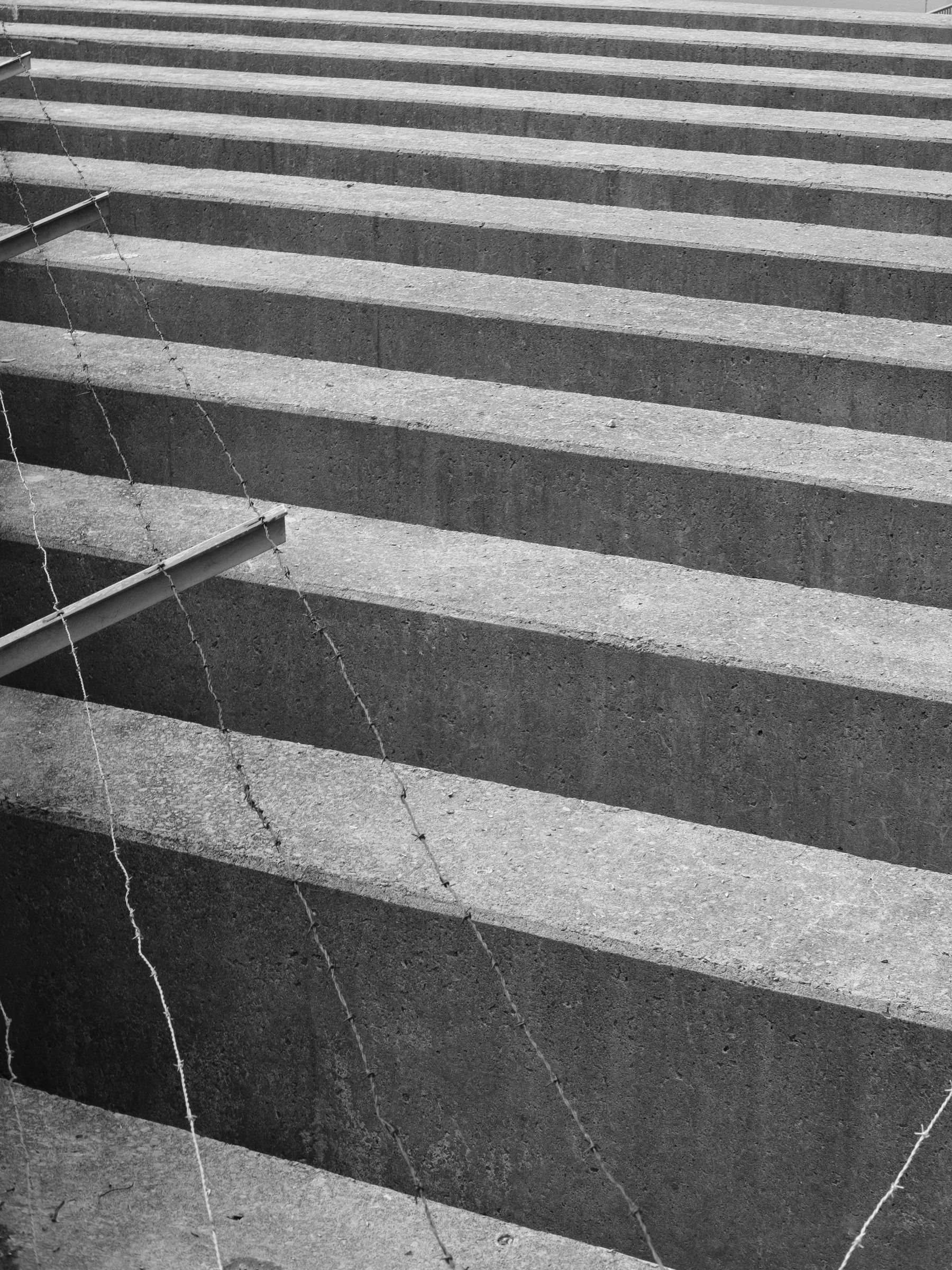 Concrete blocks and barbwire along a bridge.