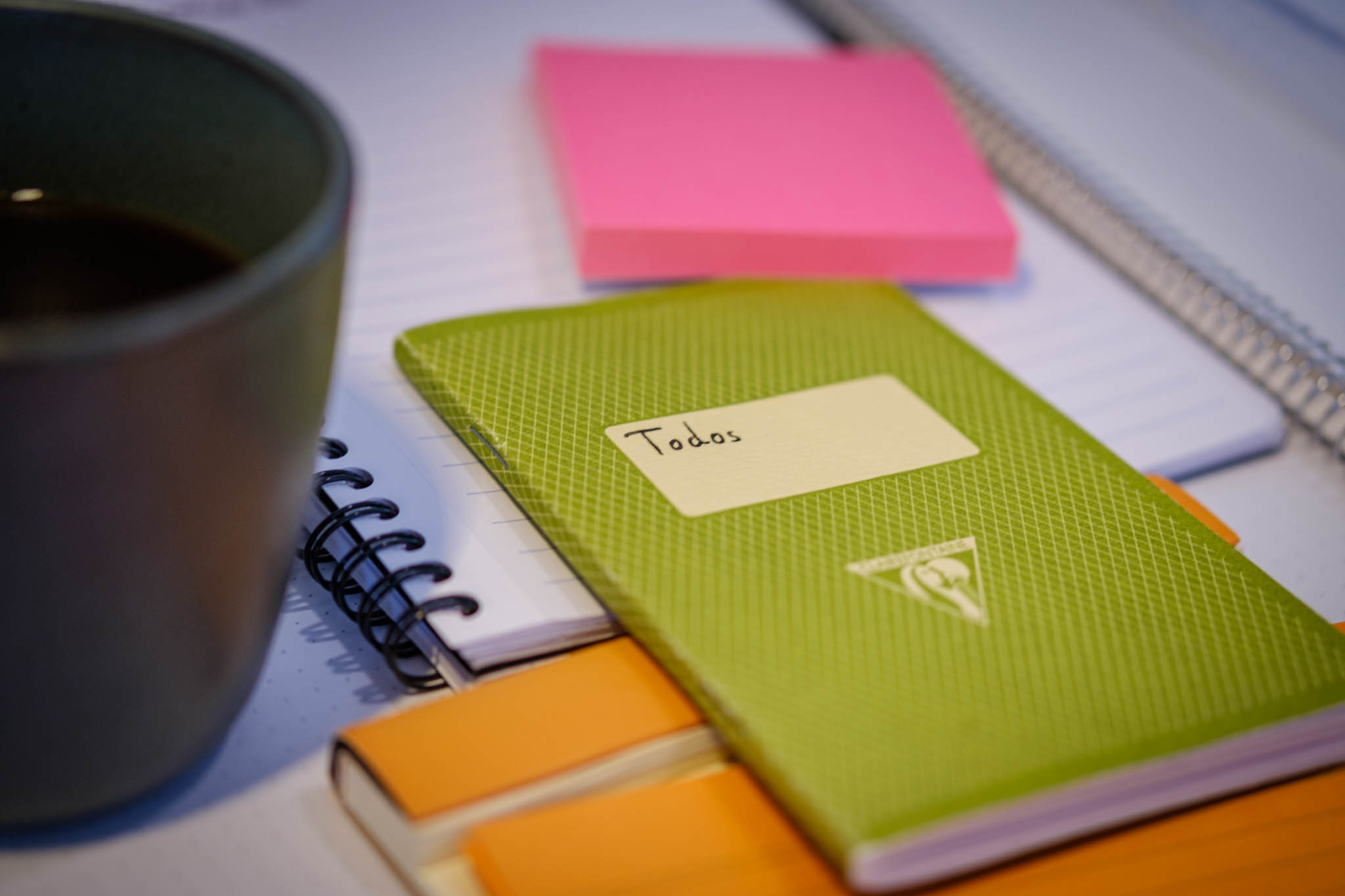 A small notebook with the word 'todo' on the front, surrounded by post-its and other notetaking items