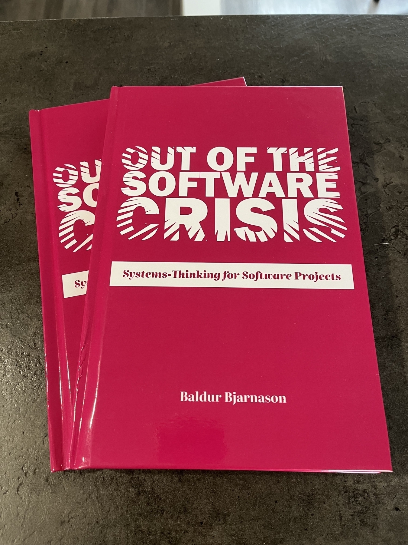 Two hardcover copies of 'Out of the Software Crisis' on a kitchen counter